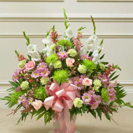 Pink and white floral arrangement with a large pink ribbon