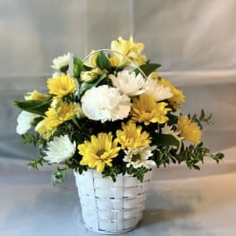Yellow and white daisy bouquet in a white basket