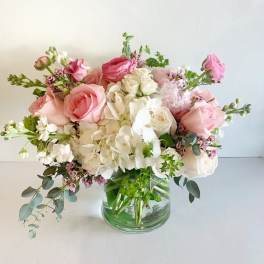 Pink and white rose bouquet in a clear glass vase