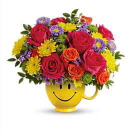 Colorful bouquet in a yellow smiley-face mug