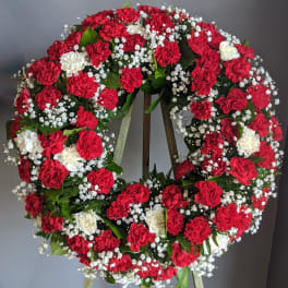 Red and white carnation wreath on a stand