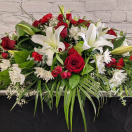 Casket spray with red roses, white lilies, and white chrysanthemums