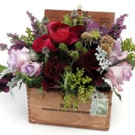 Mixed roses and filler flowers arranged in a wooden box