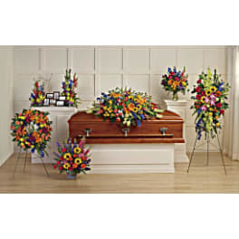 Colorful funeral casket spray with standing floral tributes