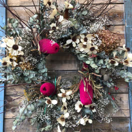Floral wreath with cream flowers and pink accents on a wooden background