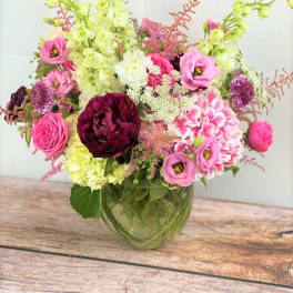 Pink and burgundy flowers arranged in a glass vase