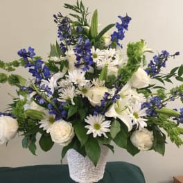 White and blue floral arrangement in a textured white vase