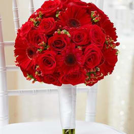 Red rose and gerbera daisy bouquet on a white chair
