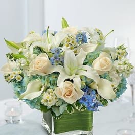 White lilies and cream roses in a square glass vase
