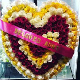 Heart-shaped rose arrangement with a pink ribbon reading "BELOVED AUNT"