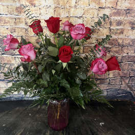 Pink and red roses arranged in a purple vase