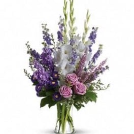 Purple and pink floral arrangement in a clear glass vase