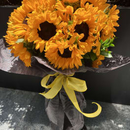 Bouquet of bright yellow sunflowers wrapped with a yellow ribbon