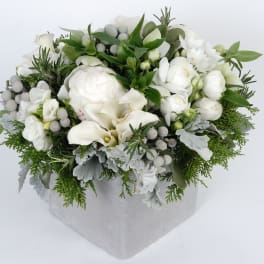White floral arrangement in a silver box with greenery