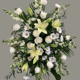 White lilies, roses, and daisies in a large standing spray