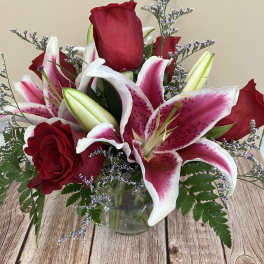 Red roses and pink stargazer lilies in a glass vase