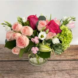 Pink and white rose bouquet in a clear glass vase