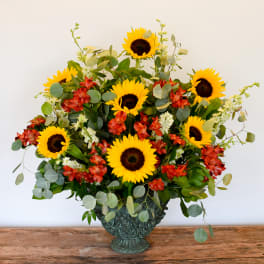 Sunflower and red alstroemeria arrangement in a decorative vase