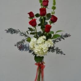 Tall bouquet of red roses and white hydrangea in a clear vase