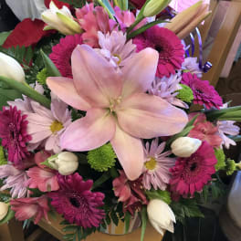 Pink lily bouquet with magenta daisies and white tulips in a vase