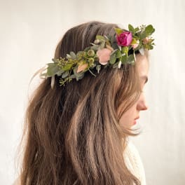 Floral crown with pink rose and peach buds worn in long brown hair in side profile view