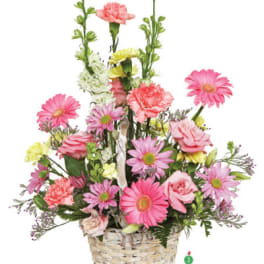 Pink and yellow mixed flowers arranged in a woven basket
