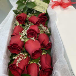 Bouquet of red roses wrapped in white paper with a red ribbon