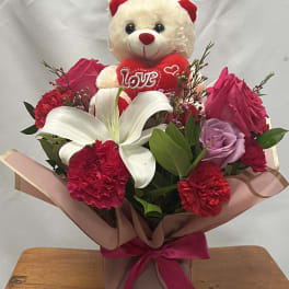 Bouquet with a teddy bear, roses, carnations, and a white lily