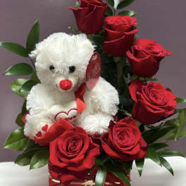 Red roses arranged with a white teddy bear in a red gift box