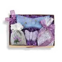 Wooden gift tray with lavender sachet bags, blue eye pillow, and a purple butterfly-shaped soap.