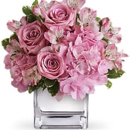 Low pink rose, alstroemeria, and hydrangea arrangement in a clear glass cube vase