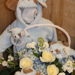 Plush puppy basket with cream roses and blue hydrangeas