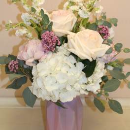Bouquet of white and blush roses with hydrangea in a pink vase