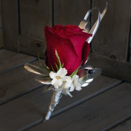 Red rose boutonniere with white flowers and silver ribbon