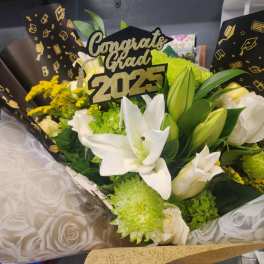 Graduation bouquet of white lilies and green mums with a Congrats Grad 2025 topper