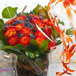 Bouquet of orange-red roses with green leaves and orange ribbon