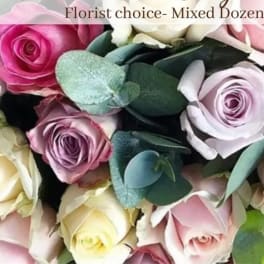 Tight cluster of mixed pink, lavender, and cream roses labeled florist choice mixed dozen