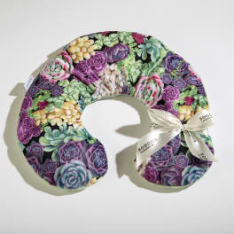 U-shaped neck pillow with colorful succulent pattern and a cream ribbon bow