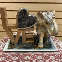 Decorative LOVE sign with a heart and elephant figurine on a tray