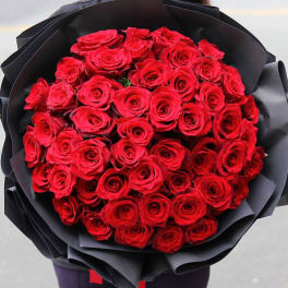 Bouquet of red roses wrapped in black paper
