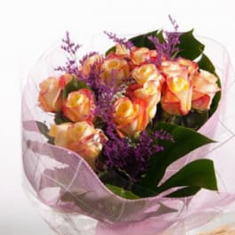Bouquet of peach and yellow roses with purple filler flowers