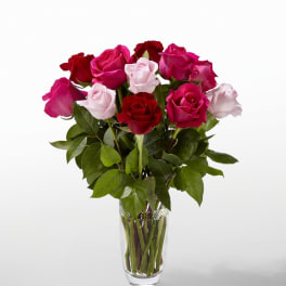 Bouquet of red, pink, and pale pink roses in a clear glass vase