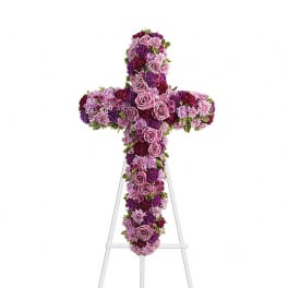 Purple and pink floral cross on a white stand