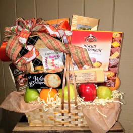 Gift basket with fruit and assorted snack boxes tied with a large ribbon