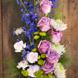 Pink roses and blue delphinium in a silver vase