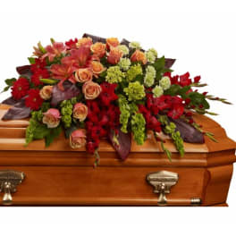 Red and peach floral spray on a wooden casket