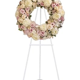 Pastel floral wreath on a white stand