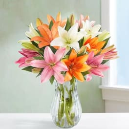 Bouquet of colorful lilies in a clear glass vase