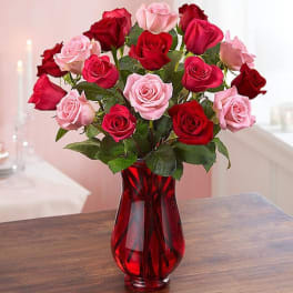 Bouquet of red and pink roses in a red glass vase