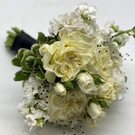 Hand-tied bouquet of ivory roses and white flowers with black bead accents and wrapped stems